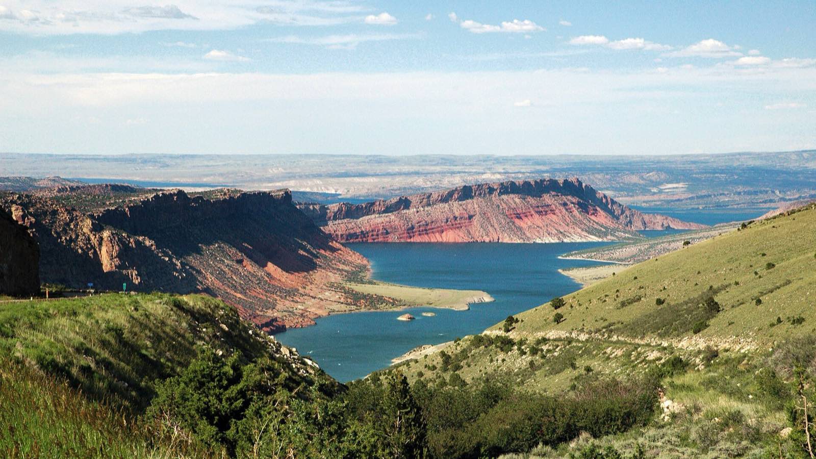 Flaming Gorge Reservoir seen from Sheep Creek Overlook in northeastern Utah, deep blue water winding between red and gray cliff bands with a pale bathtub ring along the shoreline